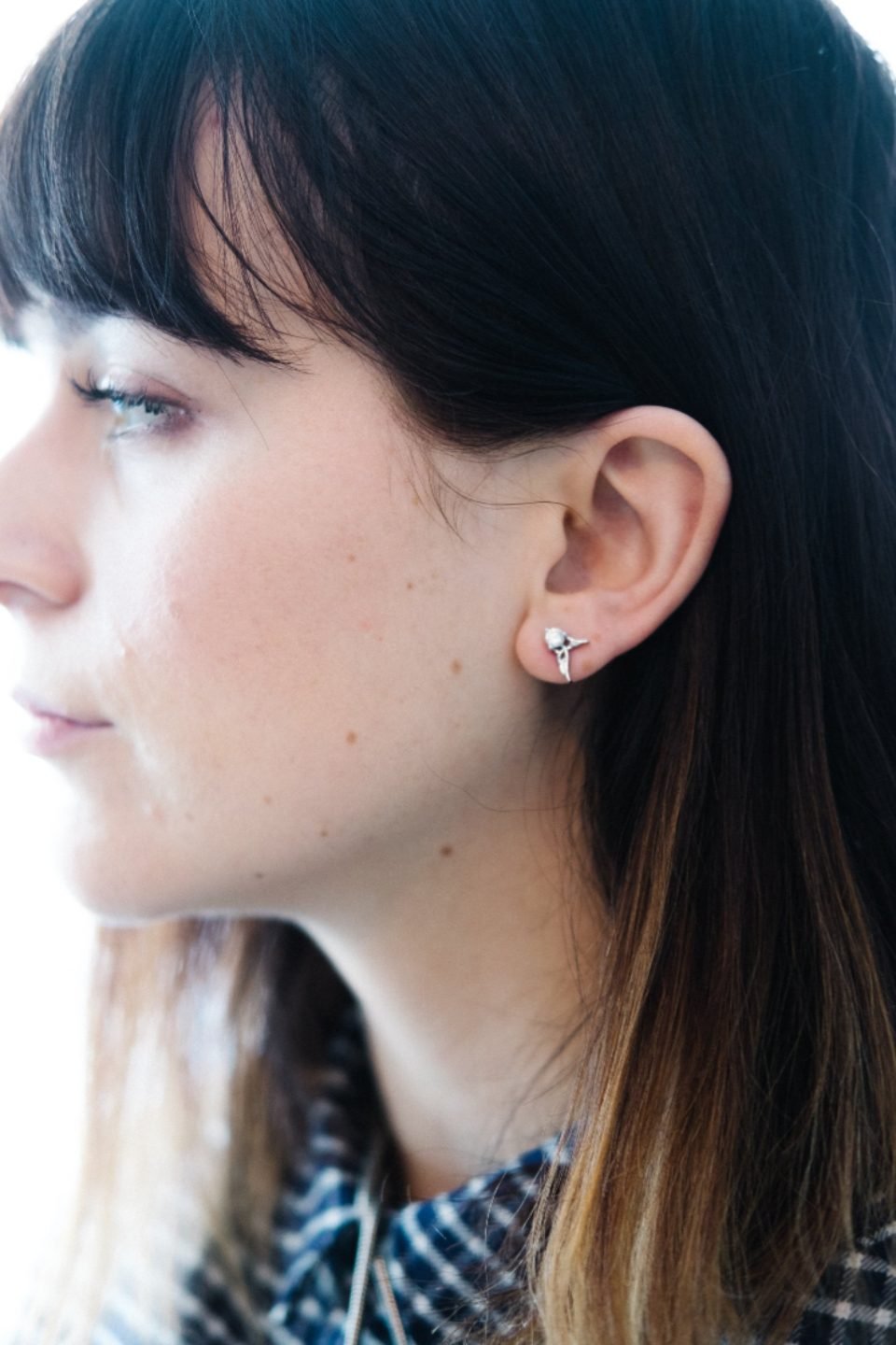 Woman wearing small silver stud earrings